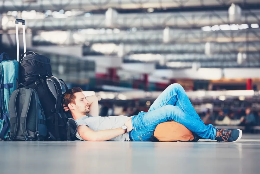 E.U. flight delays rule traveler waiting in airport.